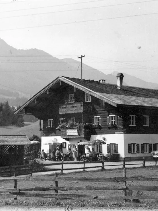 Traditionelles Alpen-Gasthaus mit Oldtimern in einem Bergtal